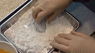 牡蠣に小麦粉をまぶし、余分な粉をはたく