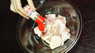 ボウルに入れた肉にコショウを多めに振っているところ