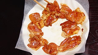 クッキングシートを敷いた耐熱皿に、皮の方を下にして肉を並べているところ