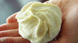 中華まんの底の大きさに合わせてオーブンシートを切り、肉まんをのせる