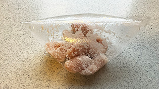 片栗粉と空気を入れて口をねじってシャカシャカ振り、片栗粉をまぶしている