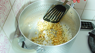 玉ねぎのみじん切りを加えて、少し色づくまで炒めている