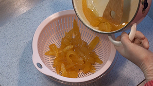煮詰めた皮をザルに取り蜜を落とす