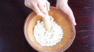 すり鉢に白玉粉、絹ごし豆腐を入れてすりこ木で豆腐をつぶしながらダマにならないように練っている