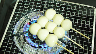 餅網で焼いて団子に焦げ目をつけている