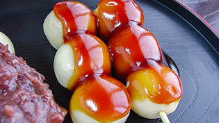 とろみがついた醤油だれを団子にからませる