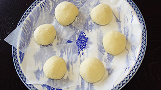 皿に1個サイズにカットしたクッキングシートを敷き、生地をのせている