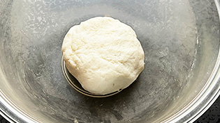 なめらかになったらホットケーキミックスを加えてゴムベラで混ぜ合わせ、手でまとまるまでこねる