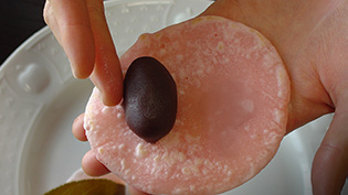 生地の粗熱がとれたら、あんを巻くように包んでいる