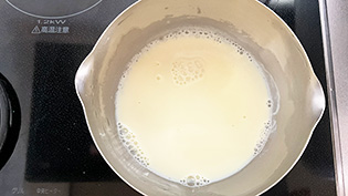 鍋に残りの豆乳を入れ、混ぜながら中火で熱し、沸騰直前で火からおろしている