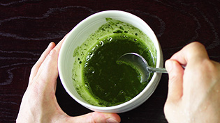 ハチミツを湯で溶かし、抹茶を加えてよく混ぜている