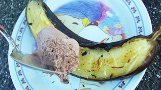両面が黒く焼きあがったら器にとって半分ほど皮をむき、アイスクリームをのせている