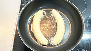 バナナの切り口を下にして置き、中火にかけ、全体がキャラメル状になるまで約2分加熱している