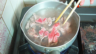 牛肉をサッと茹でて余分な脂肪とアクを取り除いている