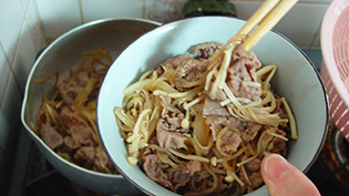 丼にご飯をよそい、具をのせ汁をかけている