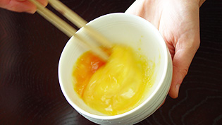 卵を軽く溶きほぐしている