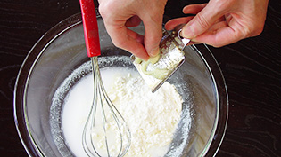 にんにくのすりおろしを加えて、泡だて器で全体を混ぜ合わせている