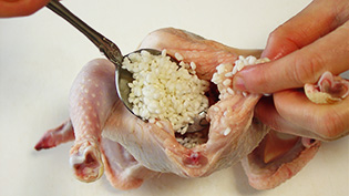 鶏のお腹にもち米を半分詰めている