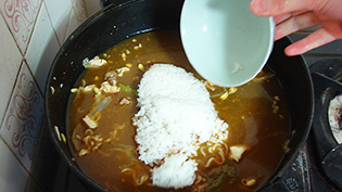 キムチ鍋の残り汁を煮立てて、冷やご飯を入れている