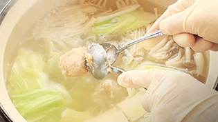 鶏肉団子をスプーン2本を使って鍋に入れる