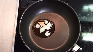 にんにくとごま油をフライパンに入れる
