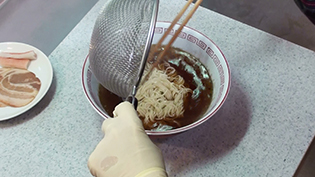 湯切りした麺を丼鉢に入れる
