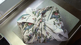 新聞紙の上からバスタオル2枚で鍋を包み、2時間冷ます