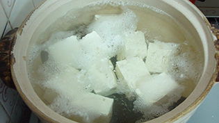 豆腐がゆらゆらしたら、すくってたれの入った器に入れる