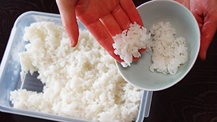 ご飯を手でお茶碗に入れる