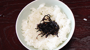 昆布をご飯にのせて指先で茶碗の縁から浮かせるる