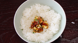 チーズ、パセリ、かつお節に醤油をかけて混ぜ合わせてご飯にのせ、指先で茶碗の縁から浮かせる
