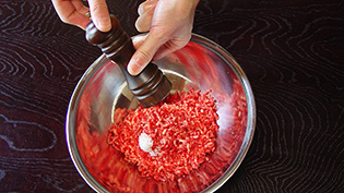 肉に塩、胡椒をしている