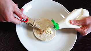 パンのヒールにマヨネーズと、粒マスタードを塗っている