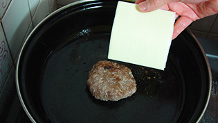 チーズをパテにのせて30秒、蒸し焼きにして溶かしている