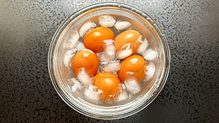 鍋から卵を取り出し、氷水に入れてすぐに冷やしている