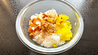 ボウルにすべての材料(温かいご飯、たくあん、チーズ、白いりごま、塩)を入れた