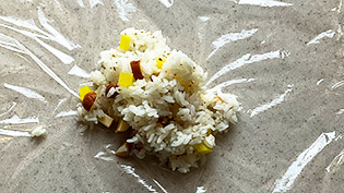 ラップを敷き、ご飯を半量のせた