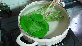 80℃の湯にわさびの葉を入れて、10秒かき混ぜている
