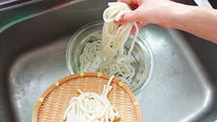 冷汁うどんの作り方:うどんをゆでて冷水でしめ、ザルに上げる