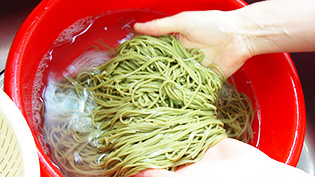 ザルにあけて水で洗っている