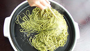 そばをホットプレートで炒めている