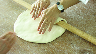 生地を手前から麺棒で巻きつけながら、押し出すように延ばしていく