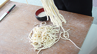 麺をふるって余分な打ち粉を落とす