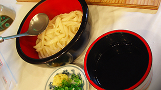 うどんを丼にとりわけ、麺が冷めないようにゆで汁も入れる