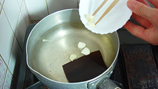 粗熱がとれた調味液にニンニクを加えているところ