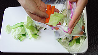 野菜と冷めた調味液をジッパー付きのナイロン袋に入れているところ