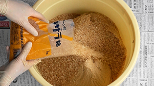 奈良漬けの下漬け方法:酒粕と砂糖を容器に入れて混ぜ合わせる