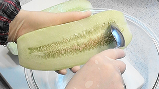 うりの種とわたをスプーンで掻き出す