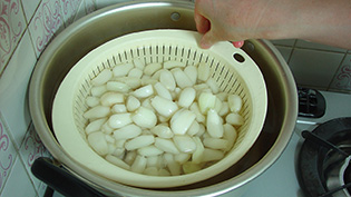 ザルに入れたらっきょうを熱湯に浸ける