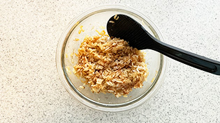 ボウルにご飯と醤油、かつお節を入れてさっくり混ぜている